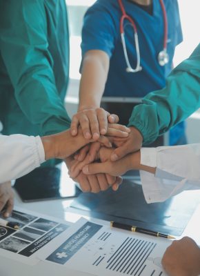 Doctors and nurses in a medical team stacking hands